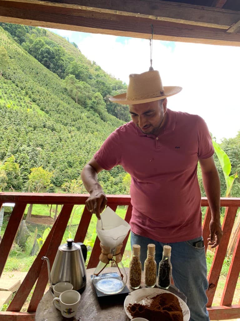Producer Andrés brewing a pour-over coffee at the farm in Huila