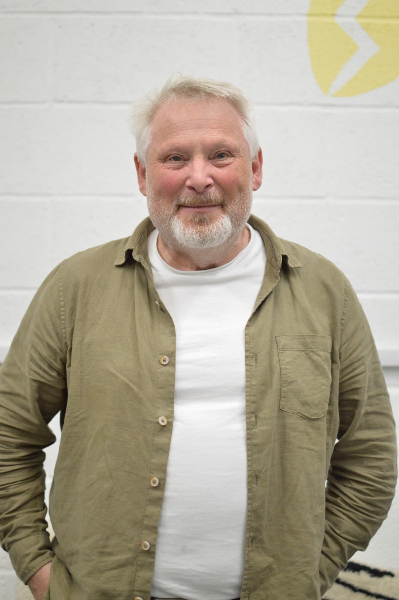 Laurence Beardmore, kWh chair, in front of the kWh logo painted on the roastery wall in York